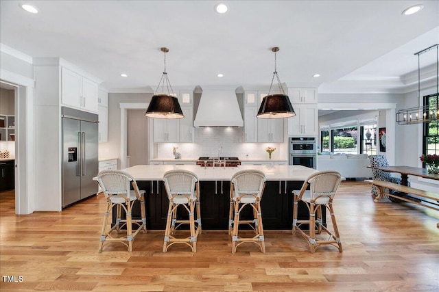 kitchen with stainless steel appliances, custom range hood, light countertops, white cabinetry, and recessed lighting