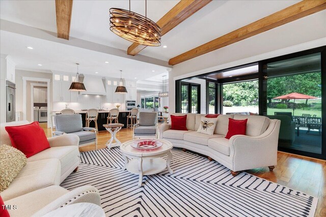 living area featuring beamed ceiling, plenty of natural light, light wood finished floors, and recessed lighting