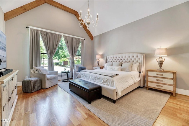 bedroom with light wood-type flooring, a chandelier, baseboards, and high vaulted ceiling