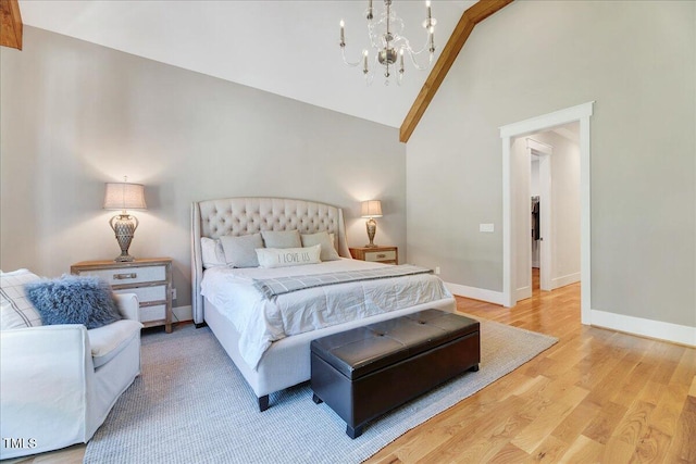 bedroom featuring a chandelier, baseboards, wood finished floors, and high vaulted ceiling