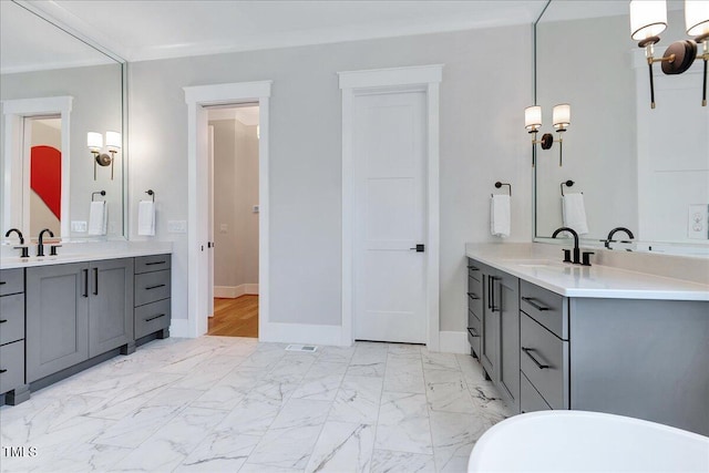 bathroom featuring baseboards, two vanities, and marble finish floors