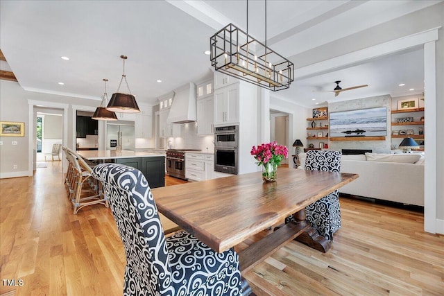 dining space featuring a ceiling fan, light wood-type flooring, recessed lighting, baseboards, and a fireplace