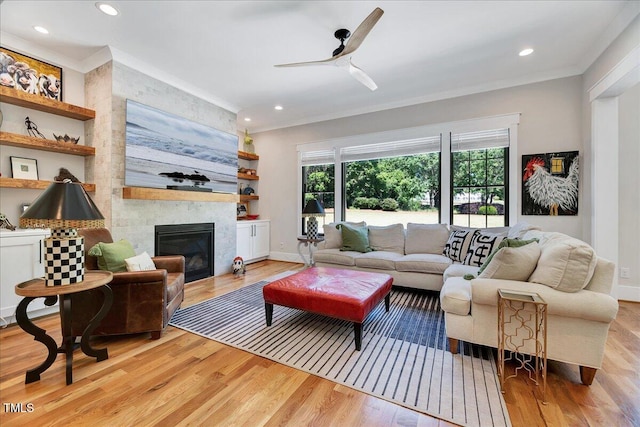 living room featuring ornamental molding, wood finished floors, ceiling fan, a fireplace, and recessed lighting