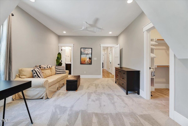 living area with recessed lighting, light colored carpet, and baseboards