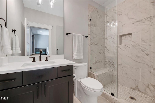 full bath featuring tiled shower, toilet, and vanity