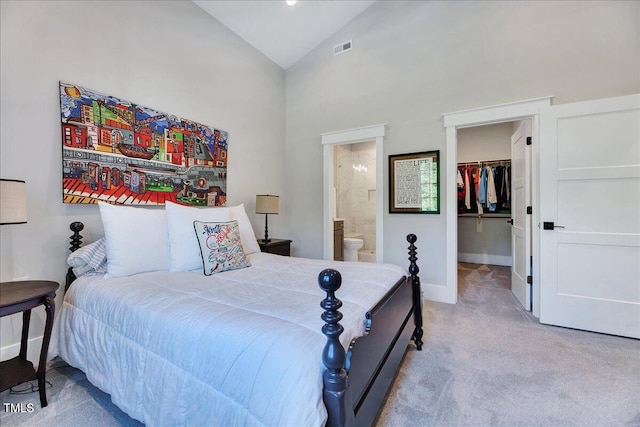 carpeted bedroom with a spacious closet, connected bathroom, high vaulted ceiling, baseboards, and a closet