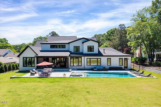 back of property featuring an outdoor hangout area, a patio area, an outdoor pool, and a shingled roof