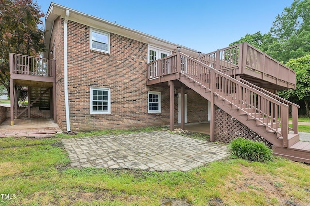 back of property featuring a patio area, stairs, a wooden deck, and brick siding