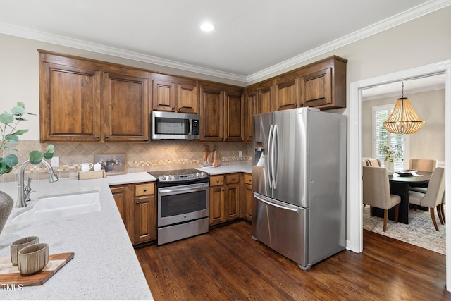 kitchen featuring appliances with stainless steel finishes, a sink, ornamental molding, dark wood-style flooring, and tasteful backsplash