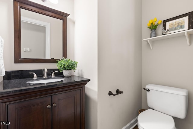 half bath featuring vanity and toilet