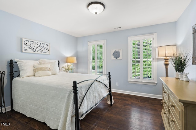 bedroom with baseboards and dark wood-style flooring