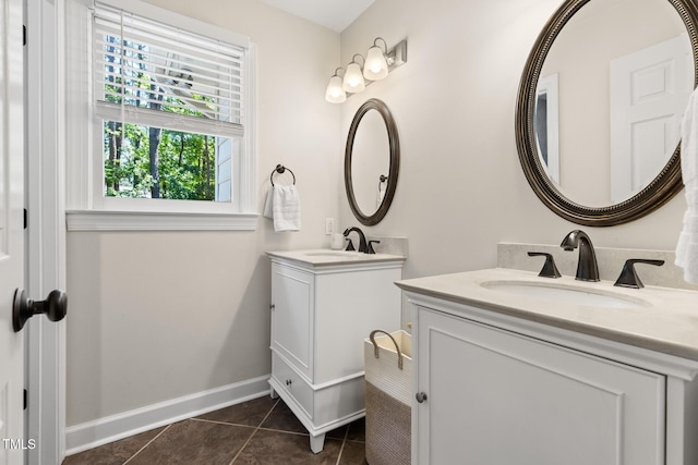 bathroom featuring two vanities, tile patterned flooring, and baseboards