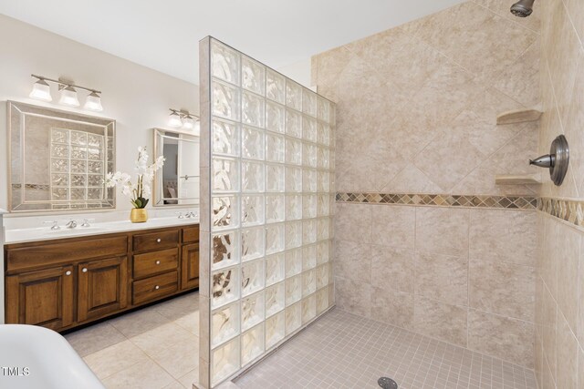 bathroom with a tile shower, tile patterned flooring, and double vanity