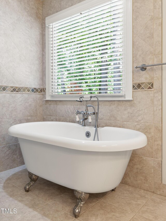 full bath featuring tile walls, tile patterned flooring, and a soaking tub