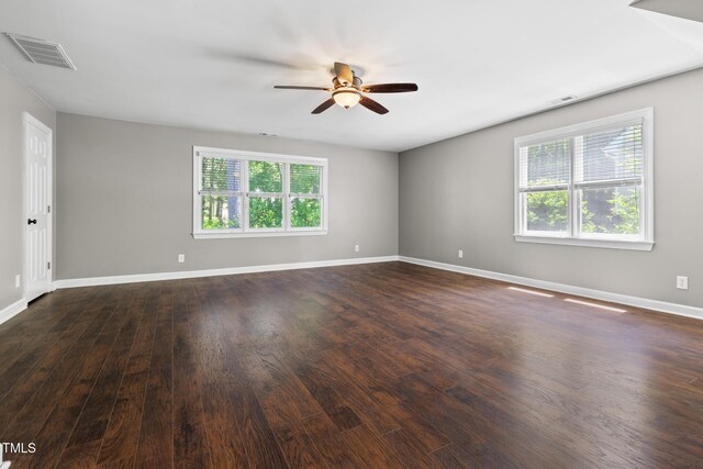 unfurnished room featuring ceiling fan, dark wood-type flooring, and baseboards