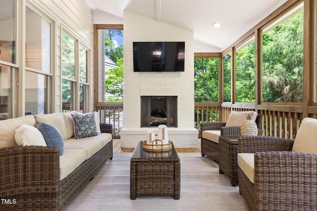 sunroom / solarium with vaulted ceiling and an outdoor living space with a fireplace