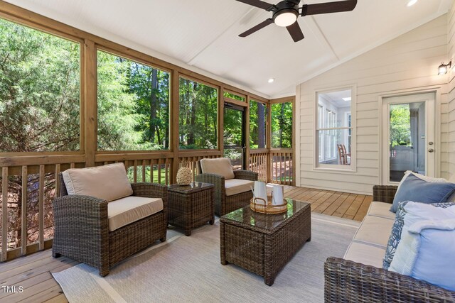 sunroom featuring a ceiling fan, outdoor lounge area, and lofted ceiling