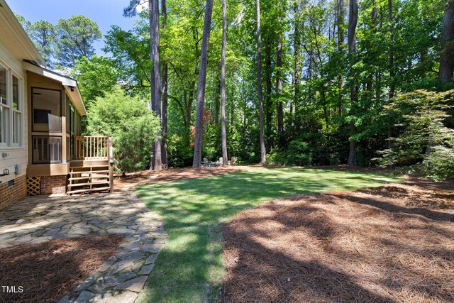 view of grassy yard featuring a sunroom