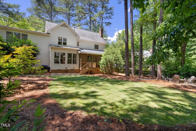 back of property with a chimney, crawl space, a lawn, and stairway