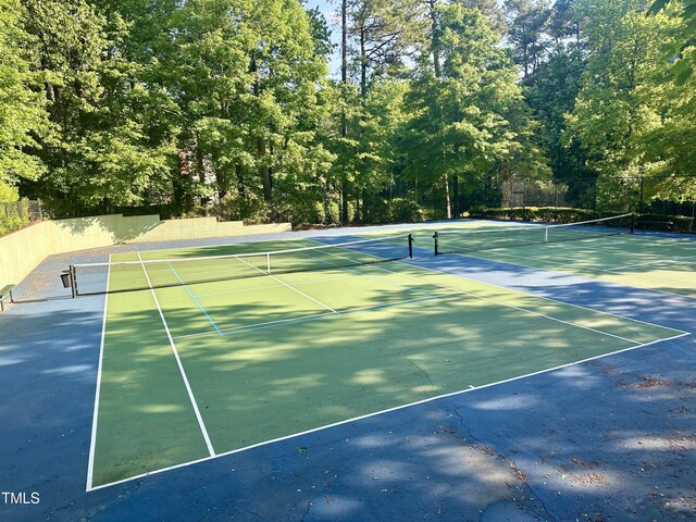 view of tennis court with community basketball court and fence