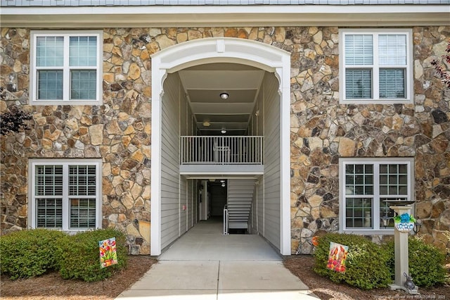 view of front of home with stone siding and a balcony
