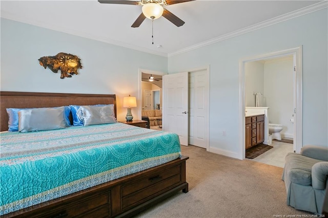 bedroom featuring baseboards, ensuite bathroom, ornamental molding, ceiling fan, and light colored carpet