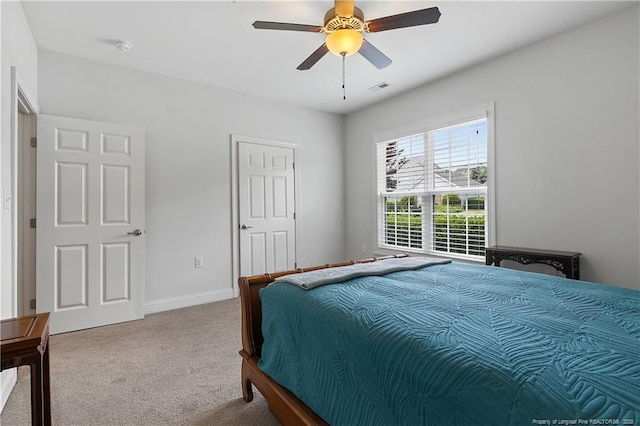 carpeted bedroom with visible vents, baseboards, and a ceiling fan