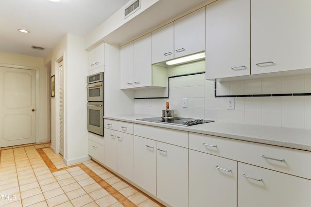 kitchen with light countertops, tasteful backsplash, white cabinetry, light tile patterned floors, and black electric stovetop