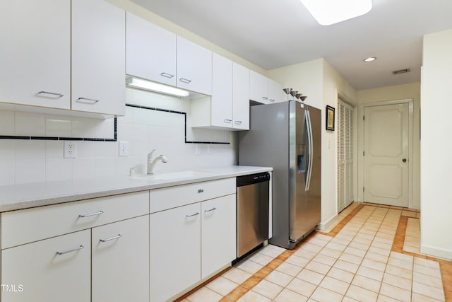 kitchen with dishwasher, a sink, light countertops, white cabinetry, and backsplash