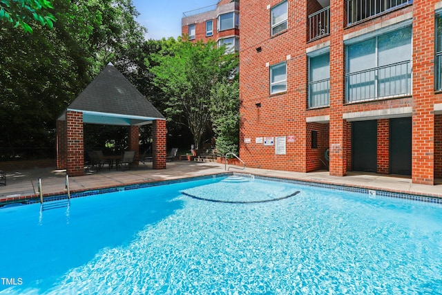 community pool with a gazebo and a patio area