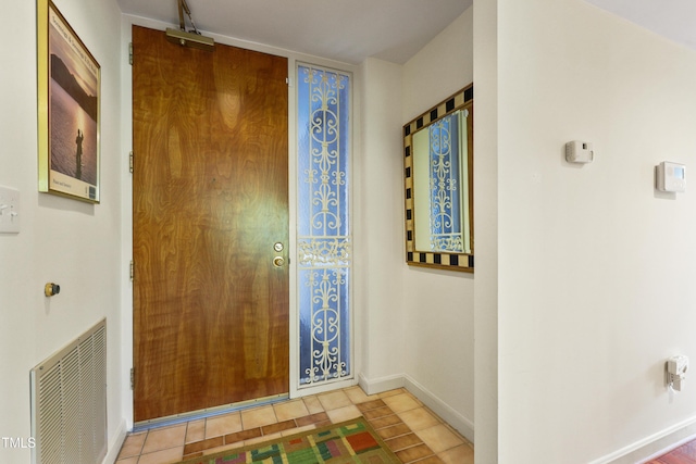 foyer entrance with baseboards and tile patterned flooring