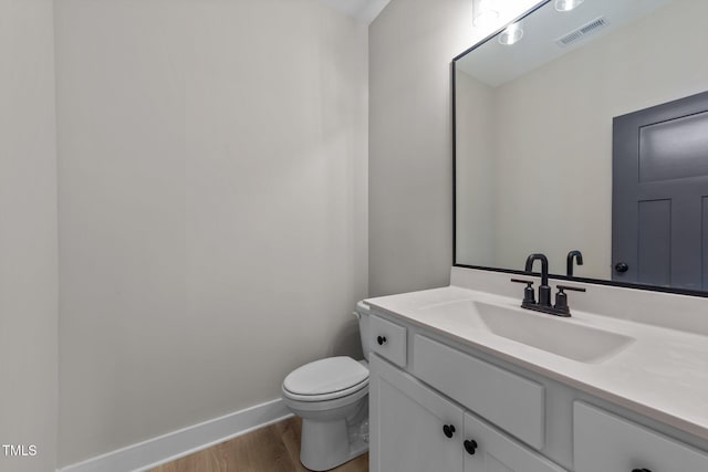 412 W Stallings St, Clayton, NC 27520 - half bath with toilet, baseboards, visible vents, vanity, and wood finished floors