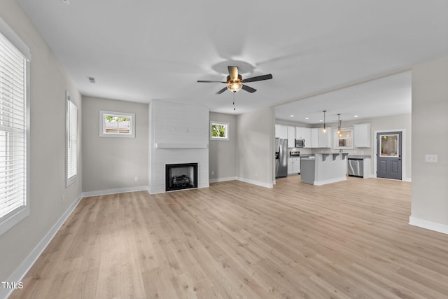 412 W Stallings St, Clayton, NC 27520 - unfurnished living room with plenty of natural light, baseboards, light wood finished floors, ceiling fan, and a fireplace