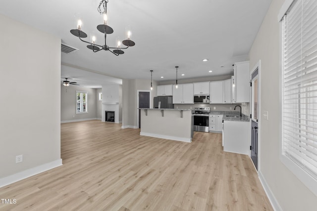 412 W Stallings St, Clayton, NC 27520 - kitchen featuring recessed lighting, visible vents, open floor plan, stainless steel appliances, and white cabinets