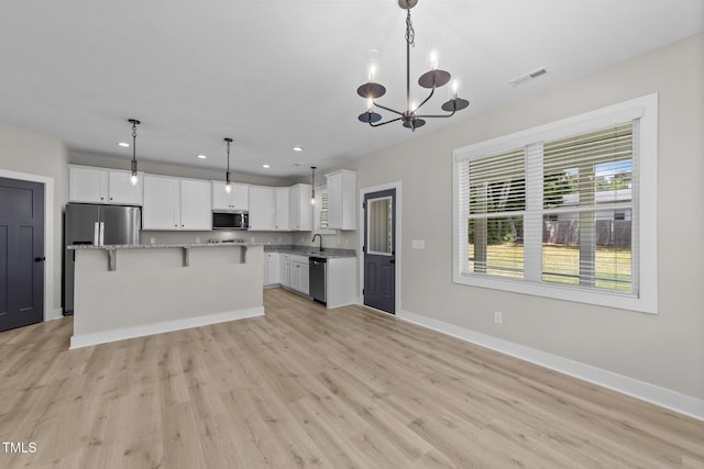 412 W Stallings St, Clayton, NC 27520 - kitchen with white cabinets, stainless steel appliances, light wood-style flooring, and visible vents