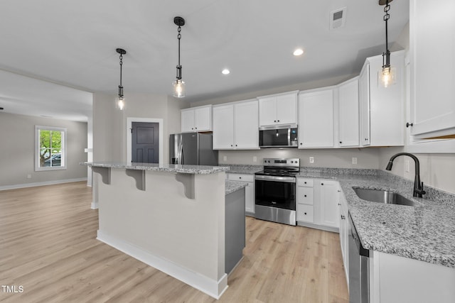 412 W Stallings St, Clayton, NC 27520 - kitchen featuring light wood-style flooring, visible vents, a sink, white cabinets, and appliances with stainless steel finishes