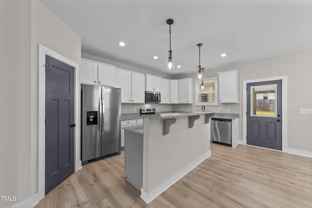 412 W Stallings St, Clayton, NC 27520 - kitchen featuring light wood finished floors, stainless steel appliances, a kitchen bar, and white cabinets