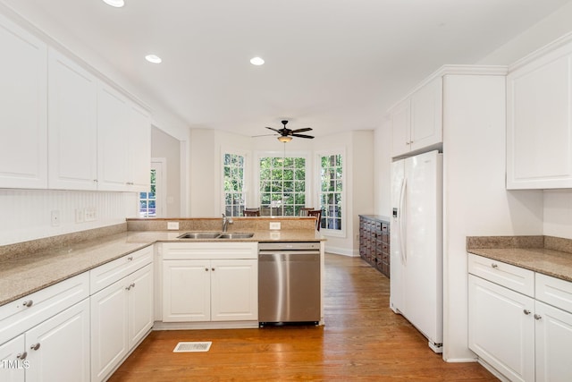 101 Rainbow Dr, Carrboro, NC 27510 - kitchen with white fridge with ice dispenser, dishwasher, a sink, light wood-style floors, and white cabinets