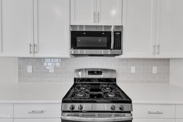 kitchen with appliances with stainless steel finishes, light countertops, white cabinets, and backsplash
