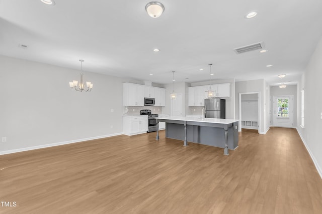 kitchen with appliances with stainless steel finishes, white cabinets, baseboards, light countertops, and recessed lighting