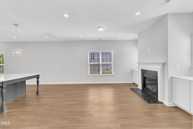 unfurnished living room with recessed lighting, light wood finished floors, a fireplace, and baseboards