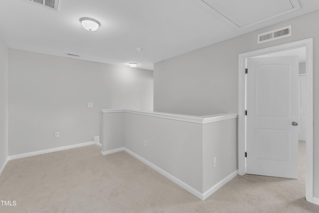 hall with an upstairs landing, carpet, attic access, and baseboards