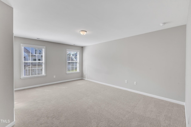 unfurnished room featuring baseboards, carpet flooring, and a smoke detector