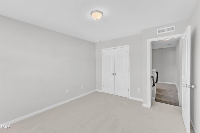 unfurnished bedroom with carpet, a closet, and baseboards