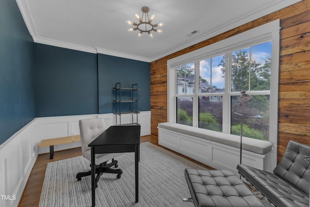 office featuring a chandelier, wooden walls, crown molding, and wood finished floors