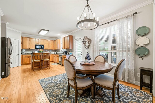 112 Nelson Ln, Clayton, NC 27527 - dining space with crown molding, light wood finished floors, and a chandelier