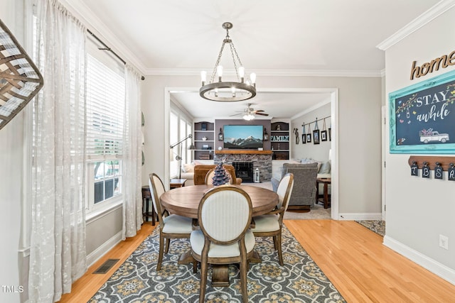 112 Nelson Ln, Clayton, NC 27527 - dining area featuring a chandelier, a ceiling fan, wood finished floors, a fireplace, and baseboards