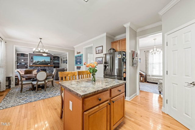 112 Nelson Ln, Clayton, NC 27527 - kitchen with a chandelier, light wood finished floors, stainless steel fridge, a kitchen island, and crown molding