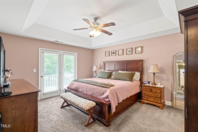 112 Nelson Ln, Clayton, NC 27527 - bedroom featuring a tray ceiling, access to exterior, light colored carpet, and ceiling fan