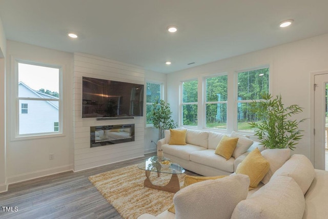 living area with recessed lighting, baseboards, plenty of natural light, and wood finished floors